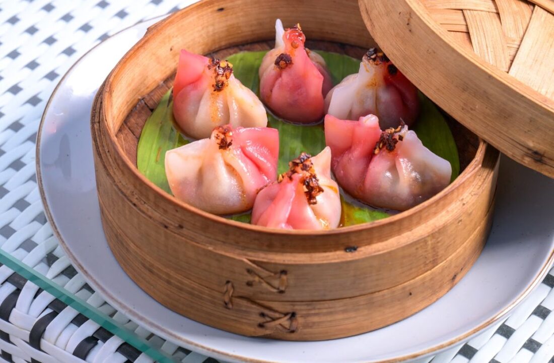 Pink dumplings on a glass table at nouba jaipur
