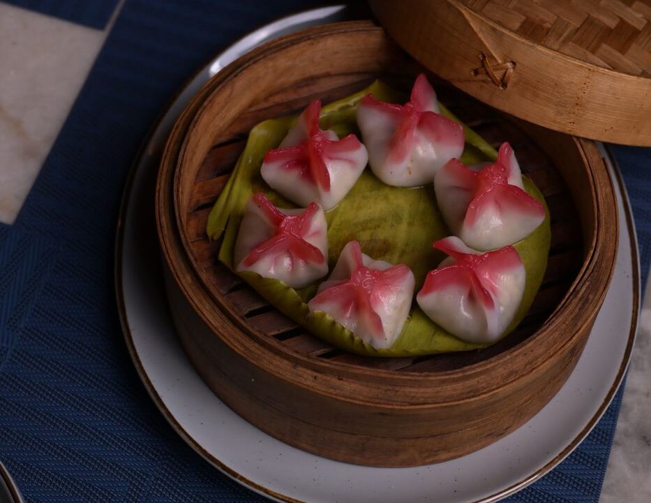 Pink and green dumplings in a steamer at nouba jaipur